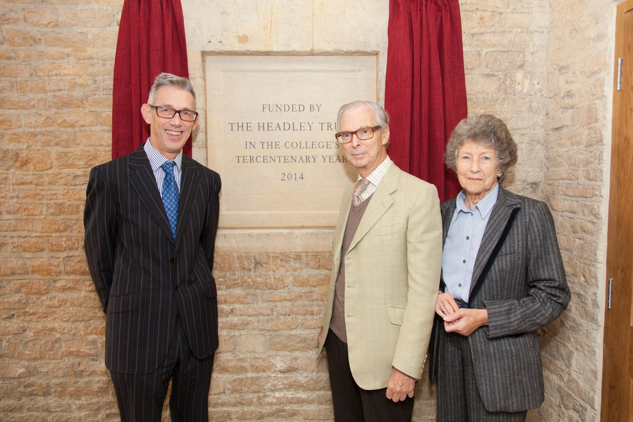 Jonathan Bate, Sir Timothy and Lady Sainsbury unveil a stone plaque marking the new kitchen development