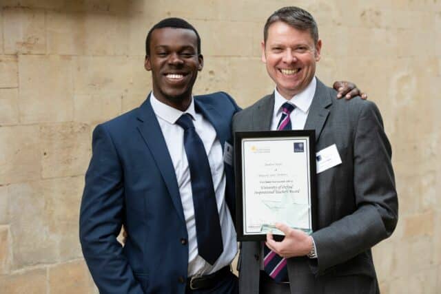 Ephraim Conteh and Jonathan Taylor holding framed certificate