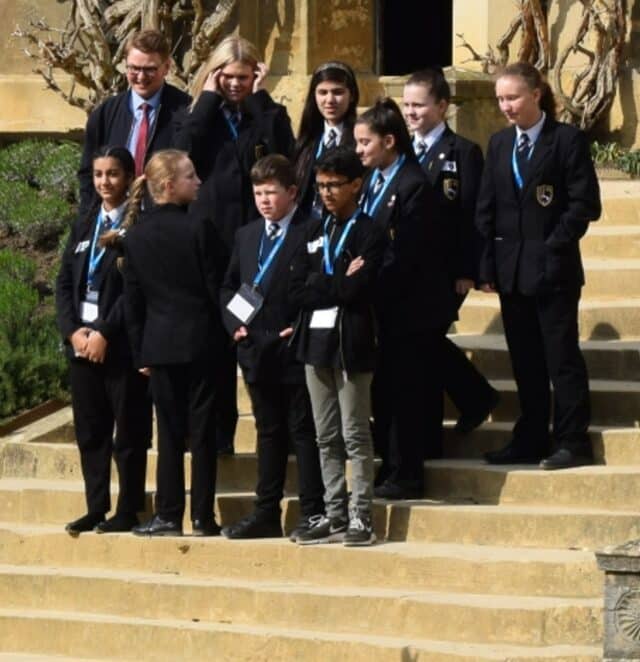 School pupils stood on quad steps