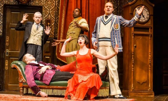 Five actors strike a pose on stage