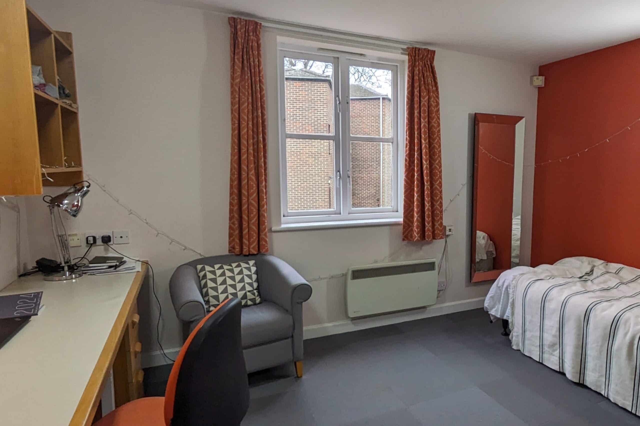 Desk, armchair and bed in Canal Building bedroom