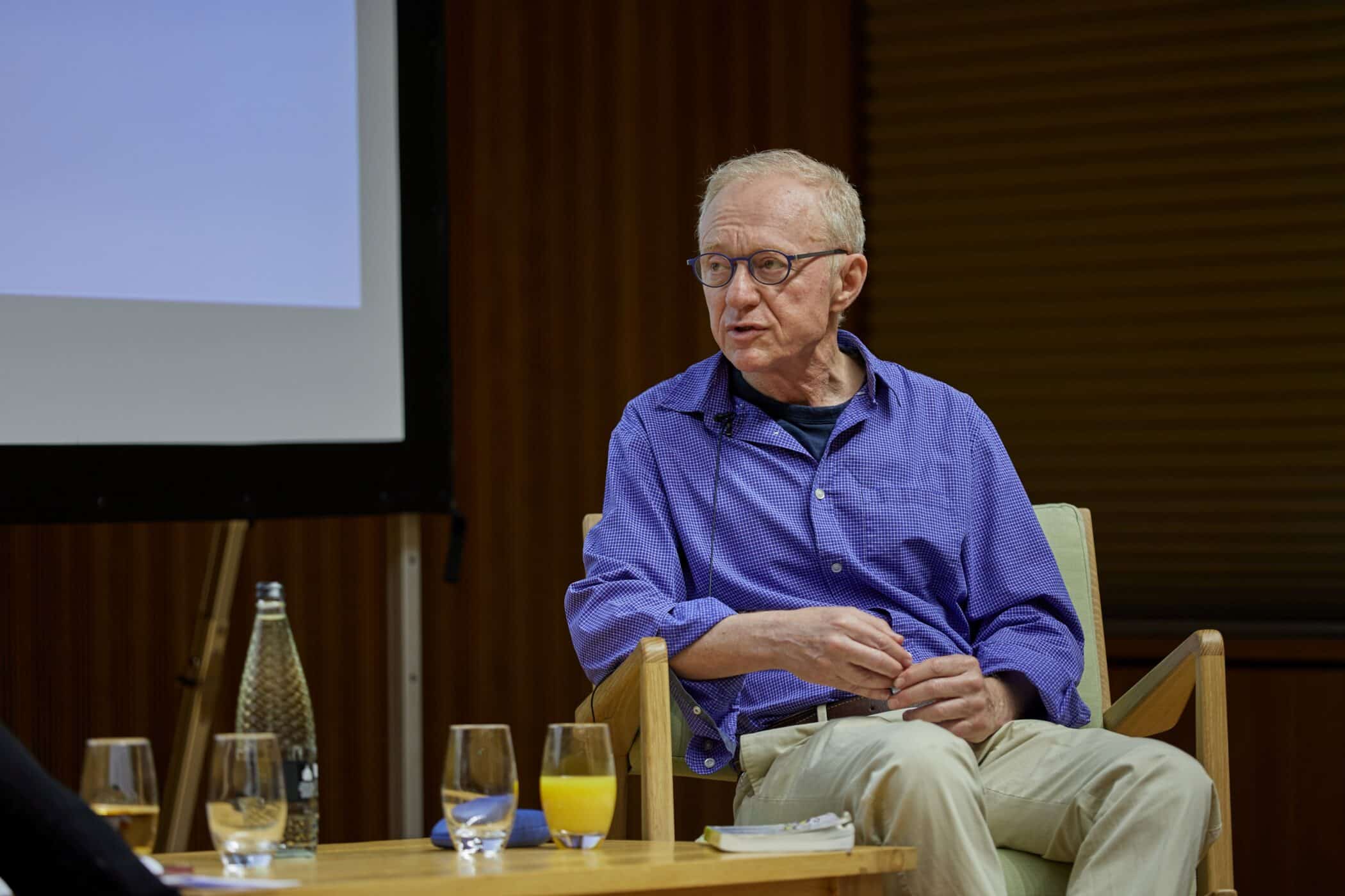 David Grossman seated on stage