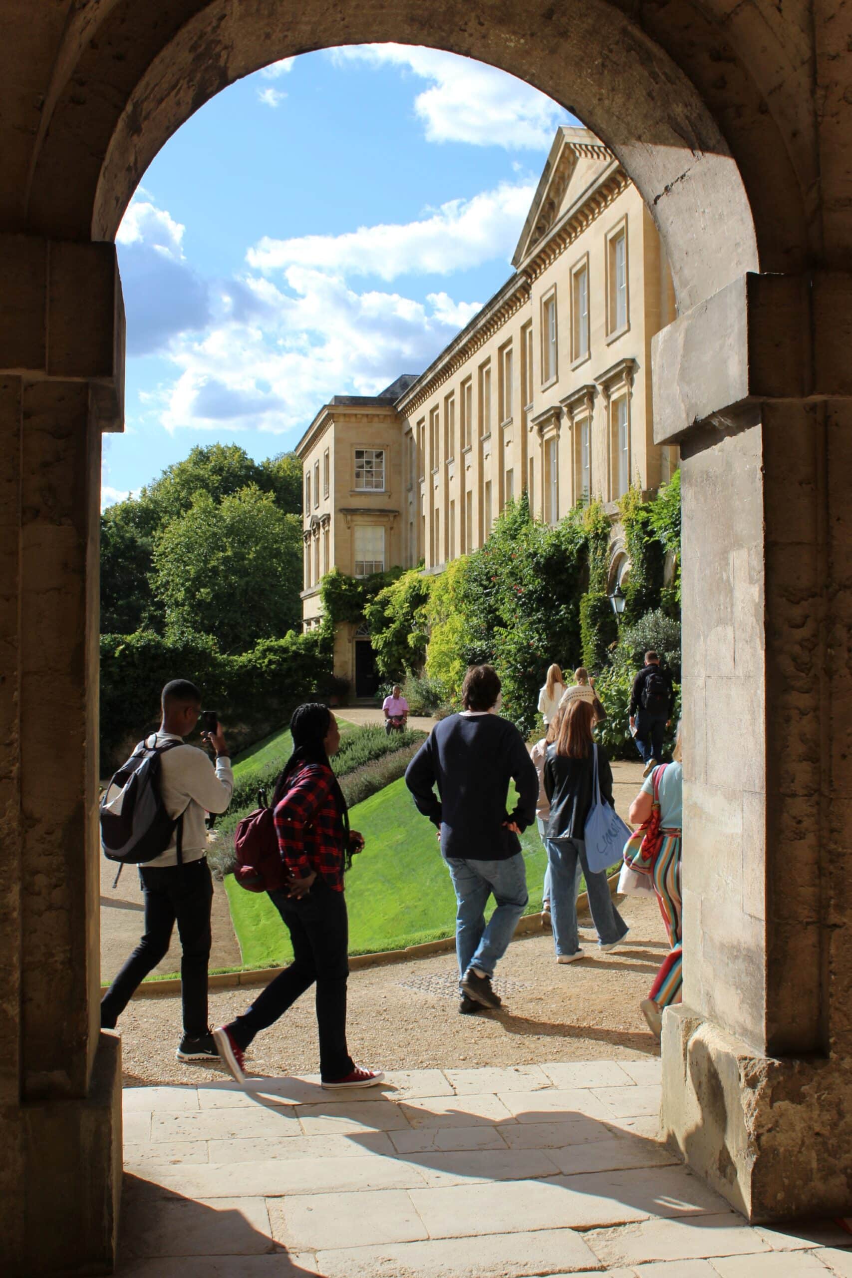 Visitors walking past an arch in the main quad