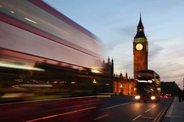 Big Ben at dusk above traffic on Westminster Bridge