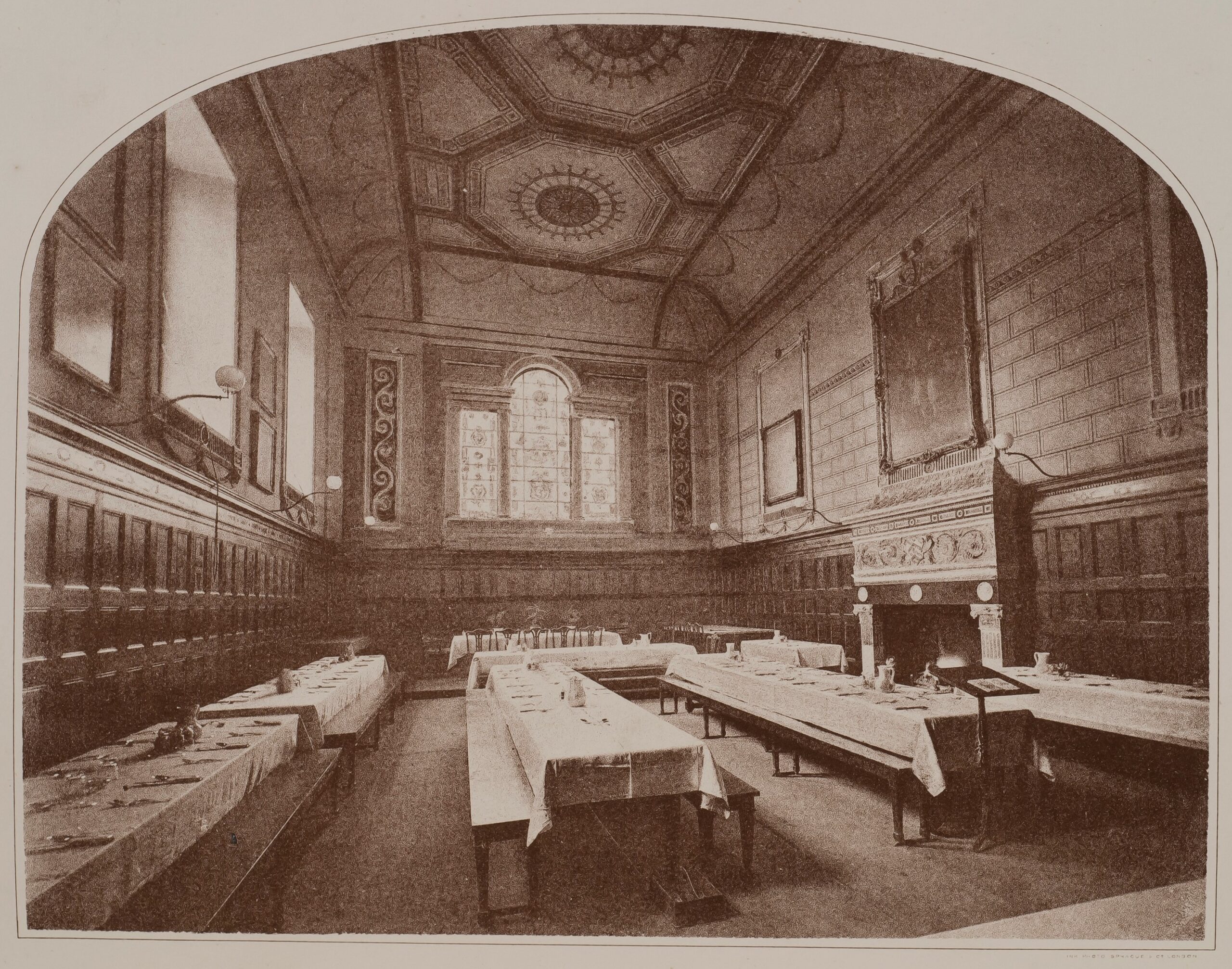 Black and white photograph of the hall looking toward the east window with wood panelling and decorated walls and ceiling.