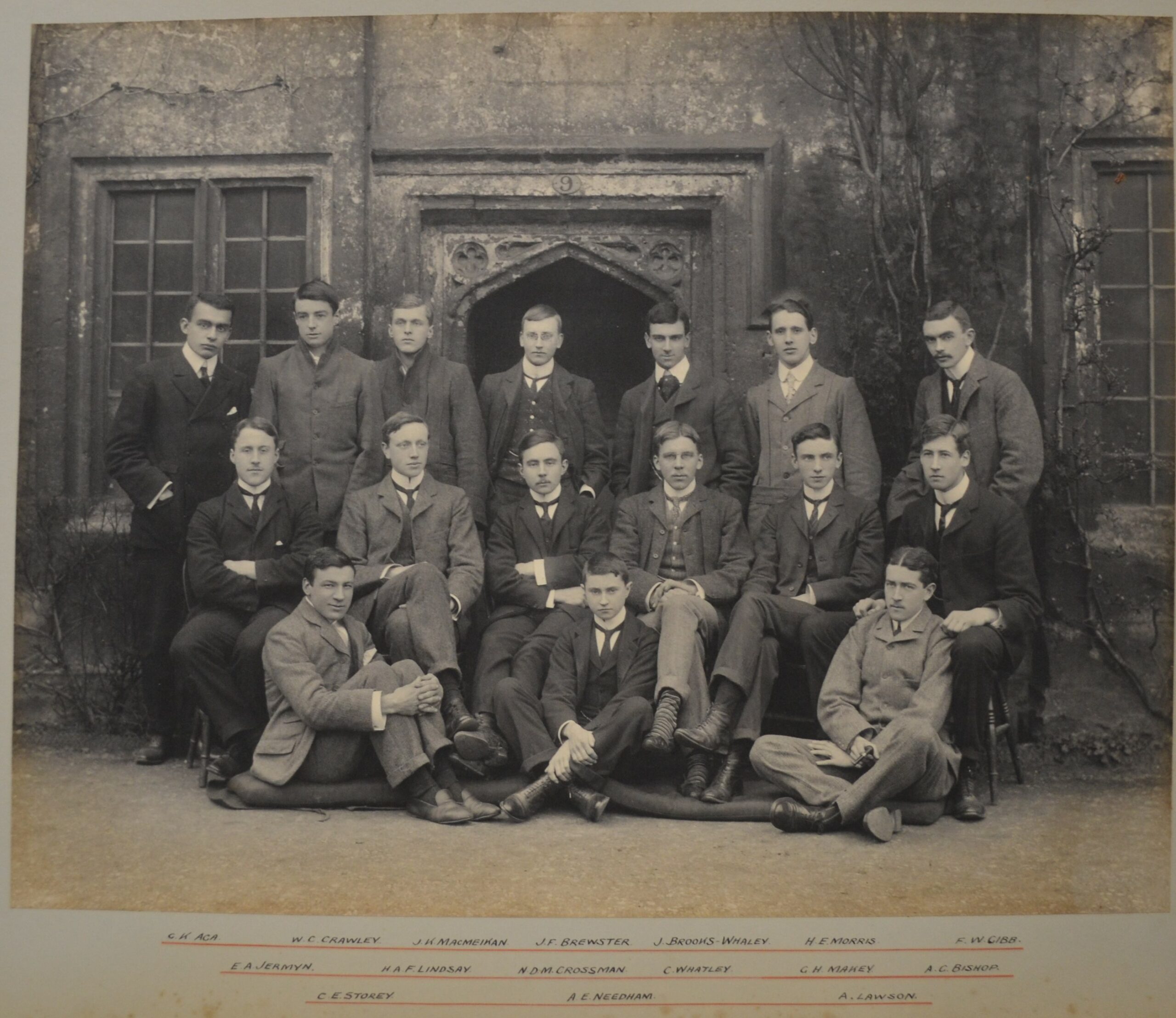 Black and white photograph of 16 young men in 1900. Taken outside a doorway in the medieval cottages.