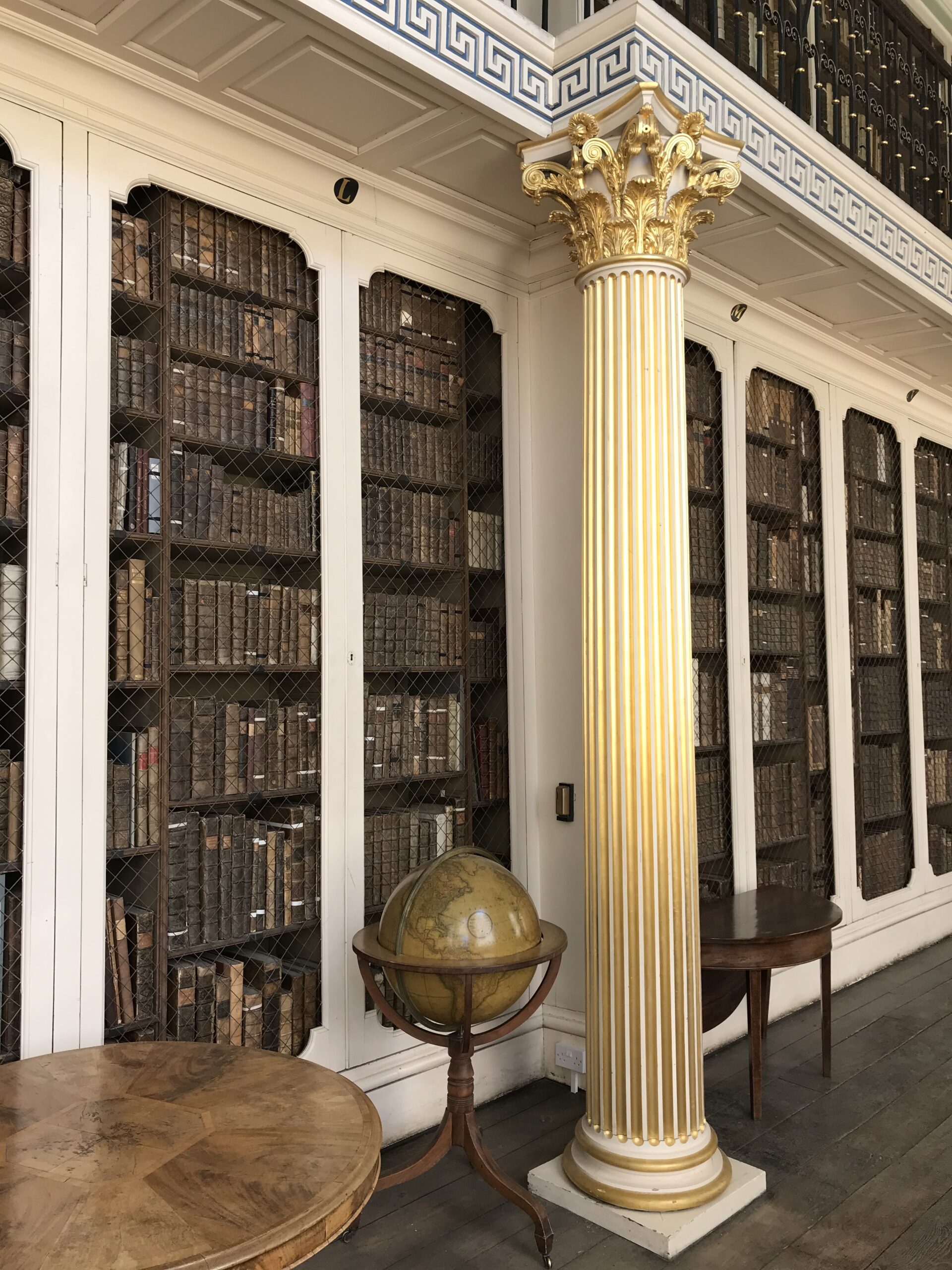 A gilt Corinthian pillar with a library globe to its left