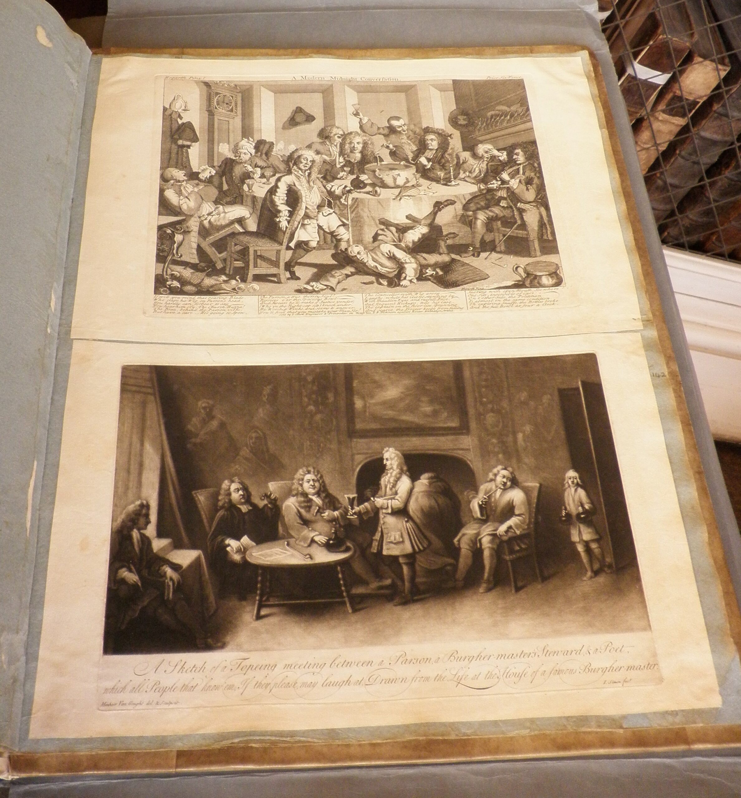 Two Hogarth prints, the top depicting a brawl, the bottom several gentlemen sat around a sitting room with drinks.