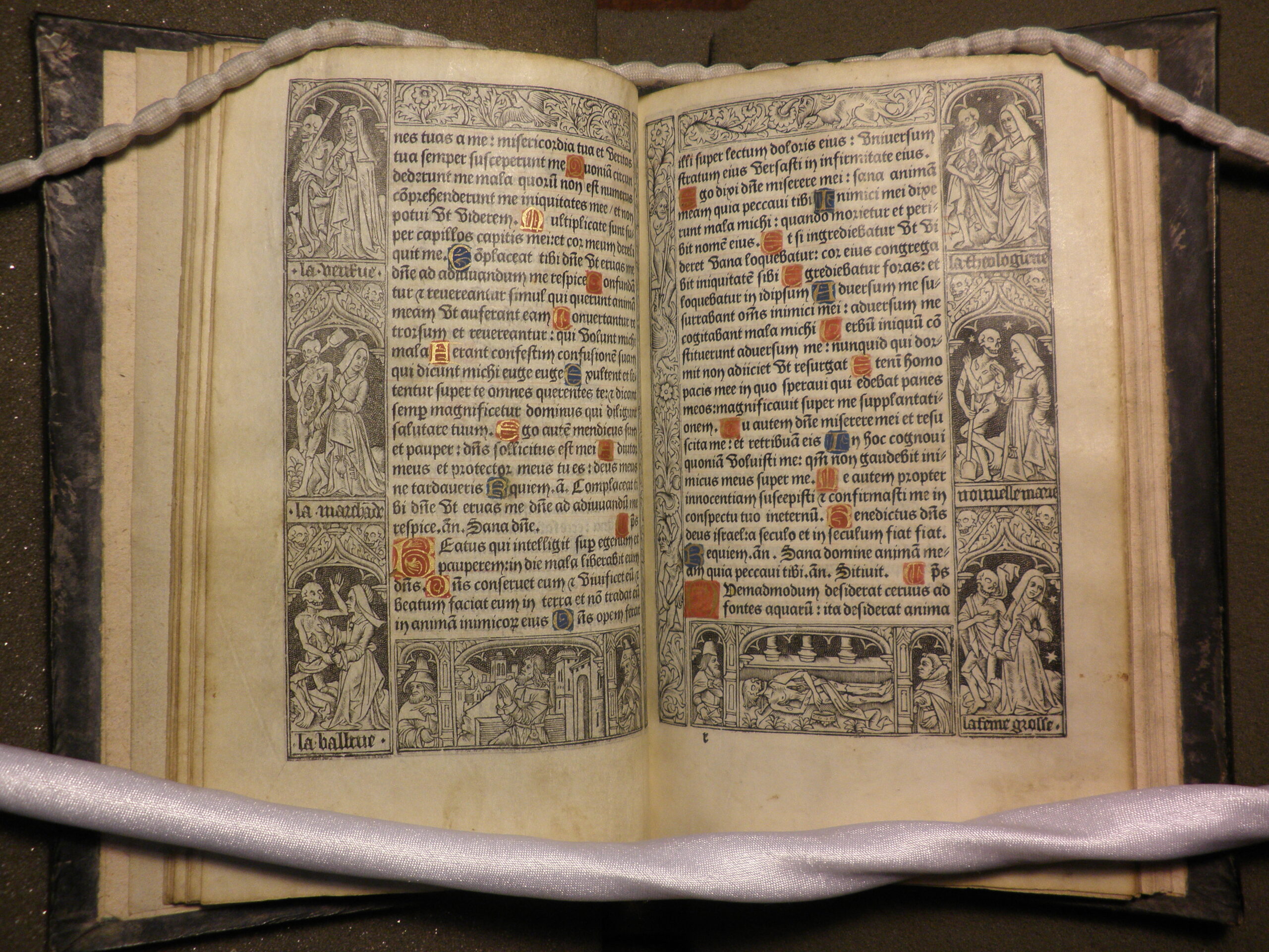 Photograph of pages from the Office of the Dead. The text is interspersed with illuminated capitals and framed with woodcuts.