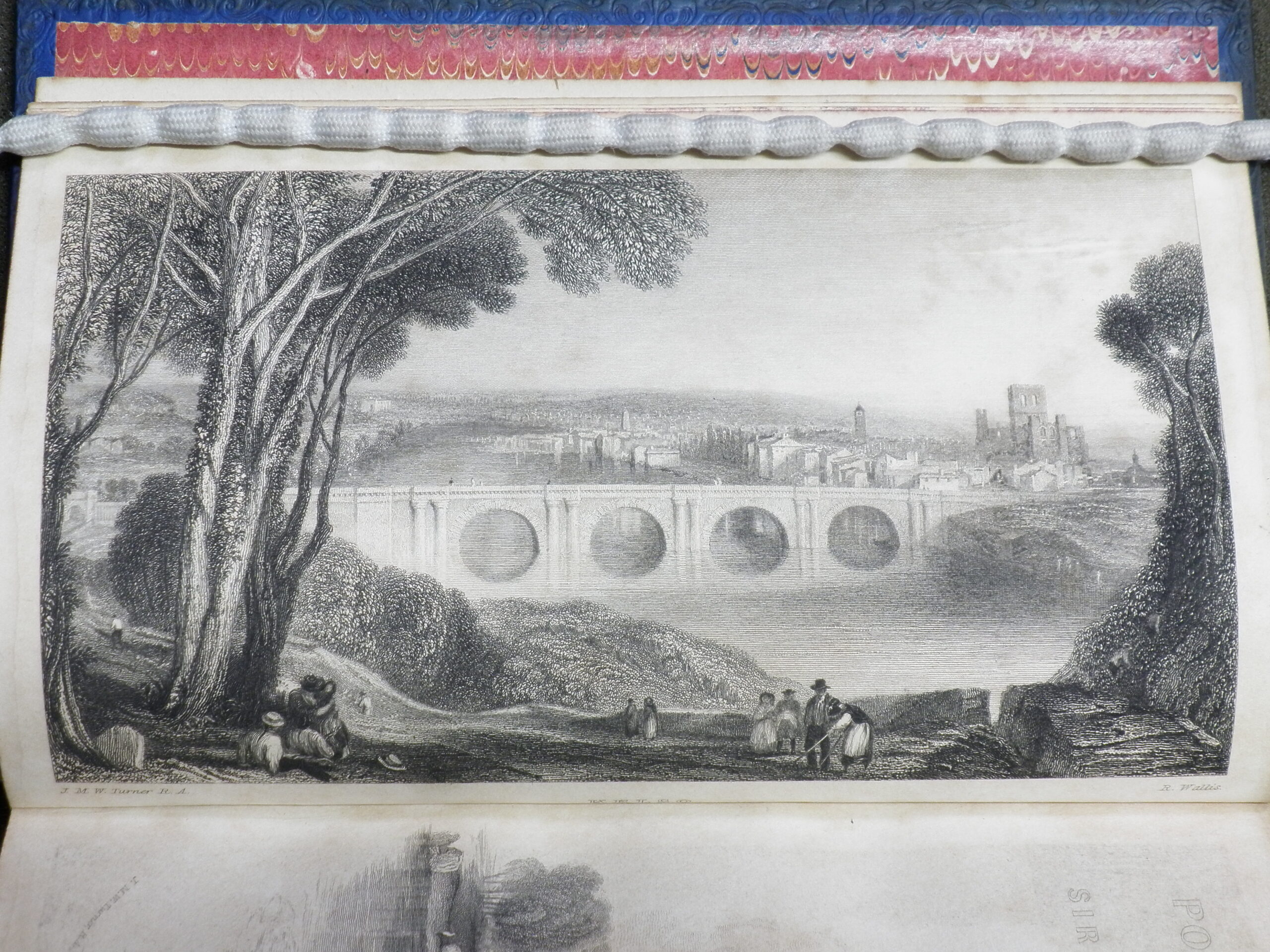 Black and white engraving showing a view of Kelso. A bridge spans a wide river and the town is on the right bank.