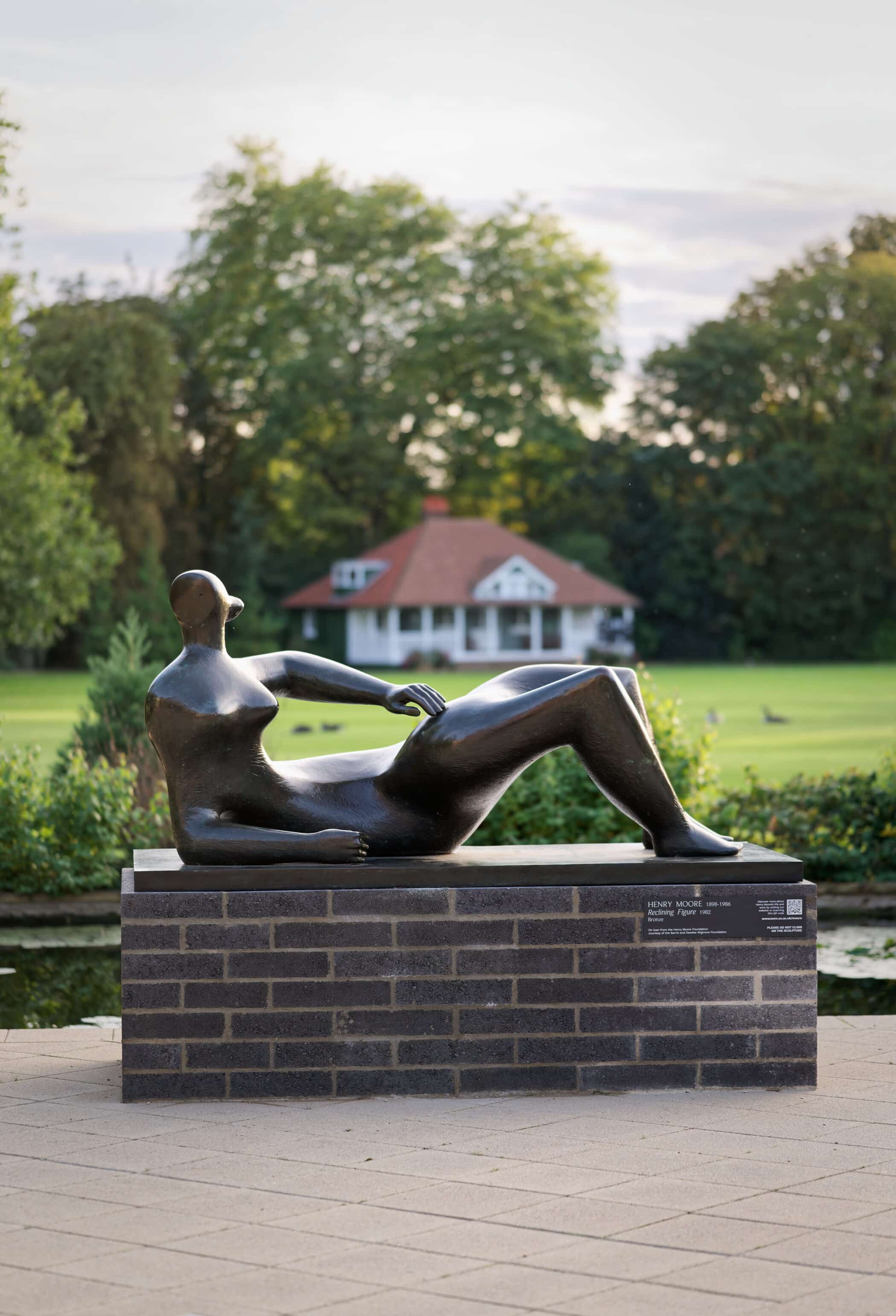 Reclining Figure by Henry Moore in front of sports field