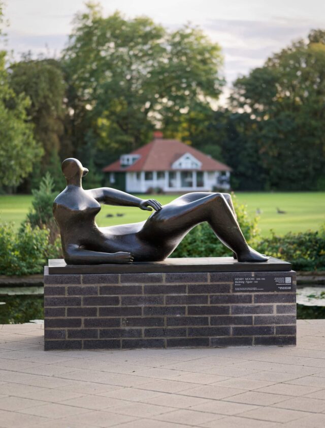 Reclining Figure by Henry Moore in front of sports field