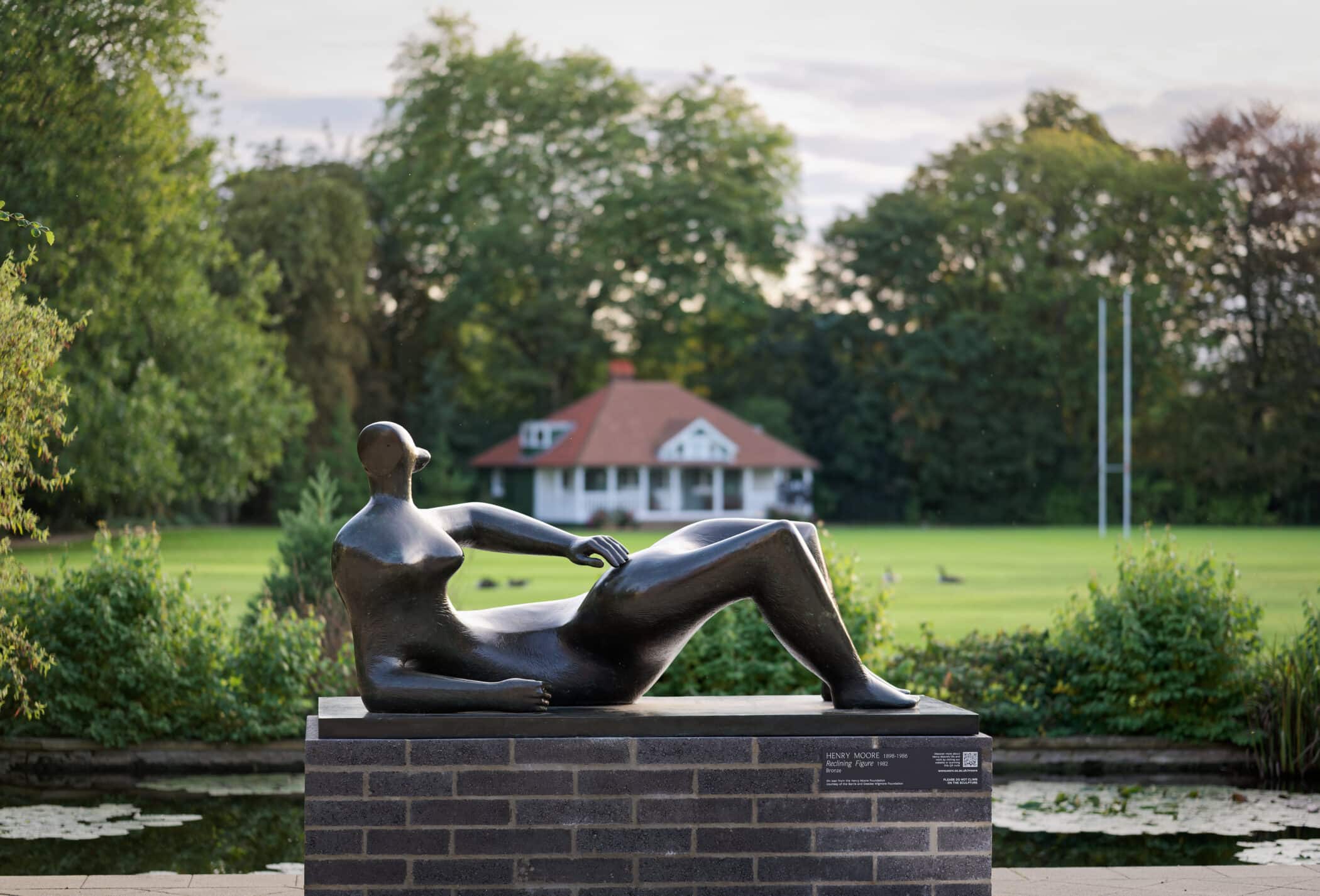 Reclining Figure by Henry Moore in front of sports field