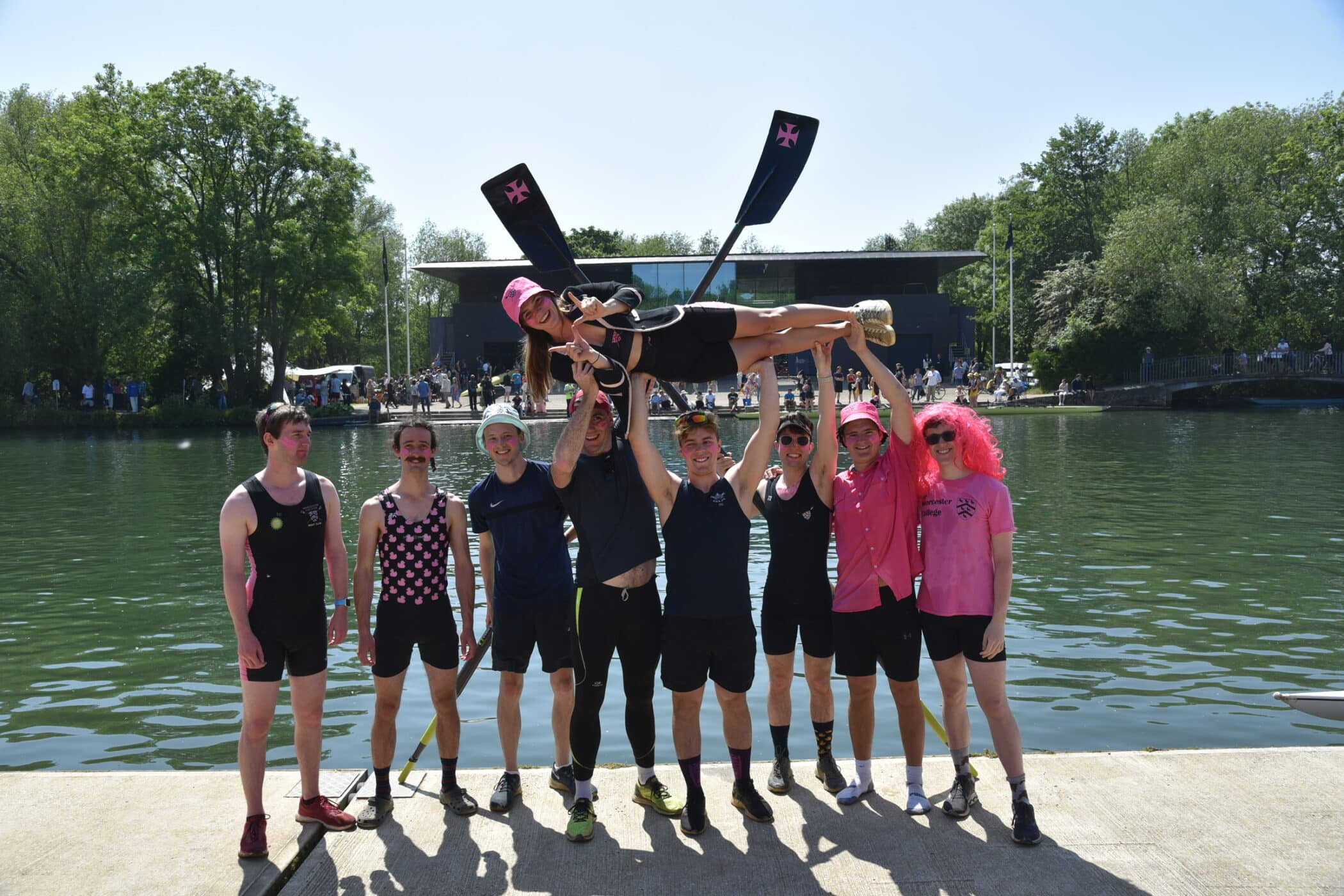 Rowers holding their cox aloft
