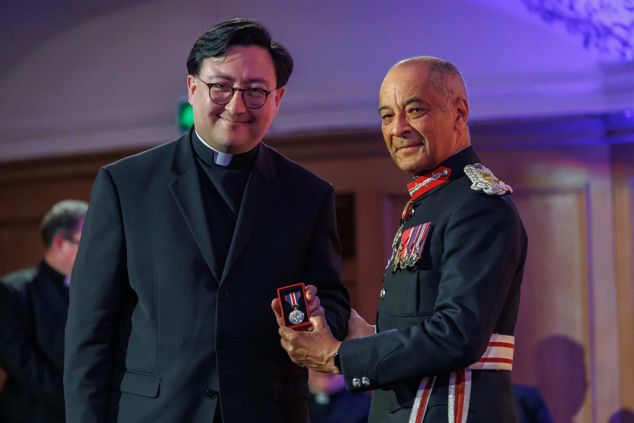 Sir Kenneth Olisa presenting the King's Coronation Medal to the Revd Dr Matthew Salisbury