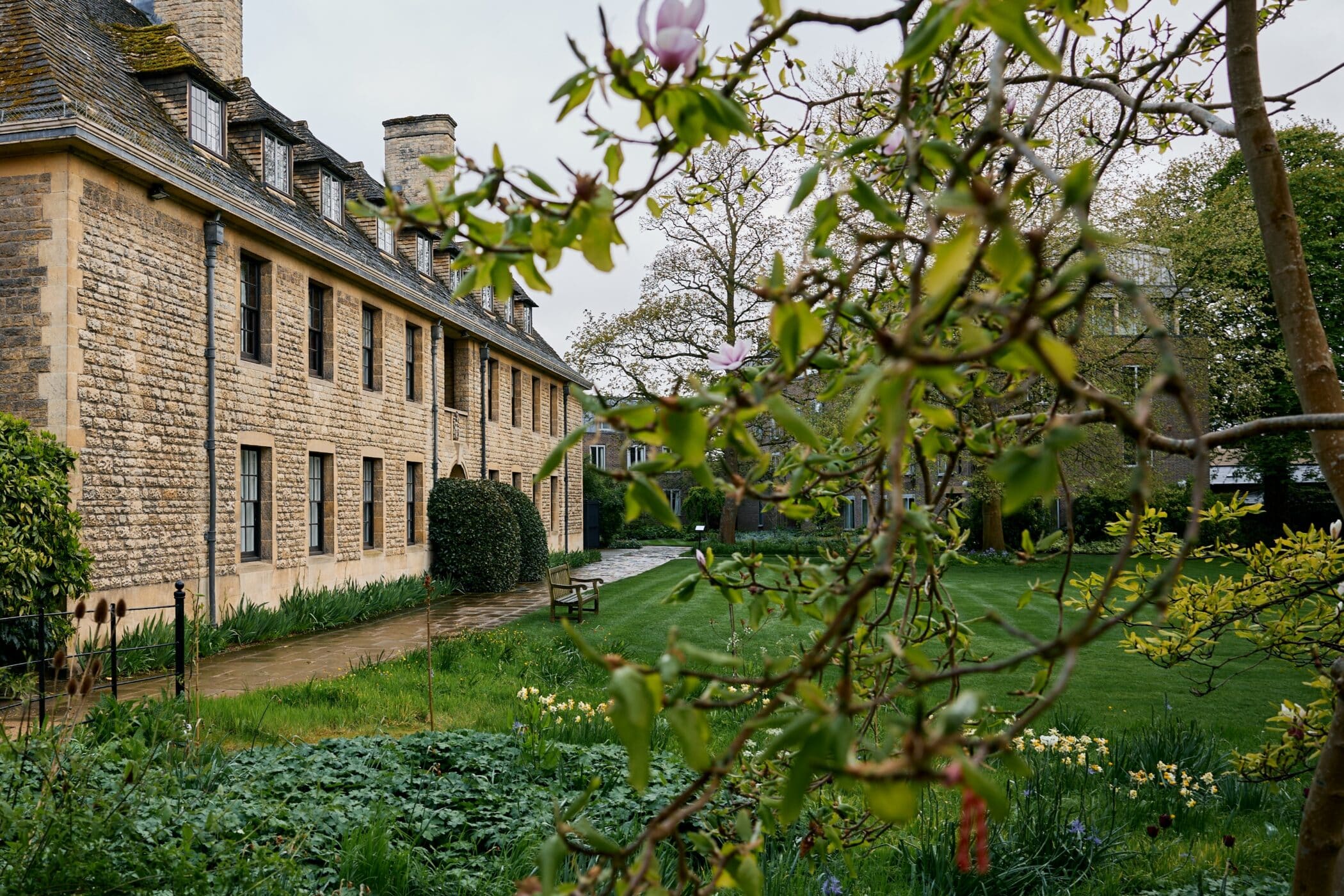 Stone building next to lawn with spring flowers