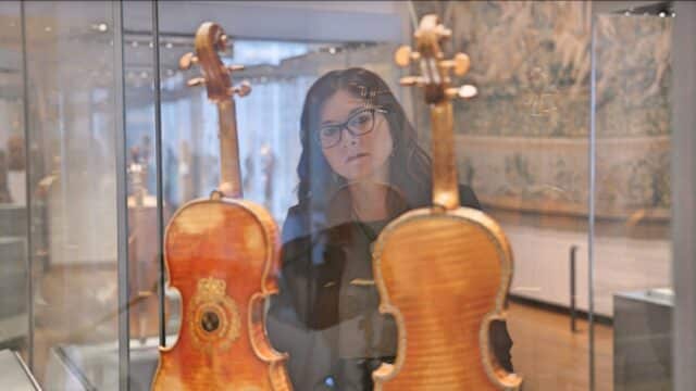 Emanuela Vai looking at historic violins in the Ashmolean Museum