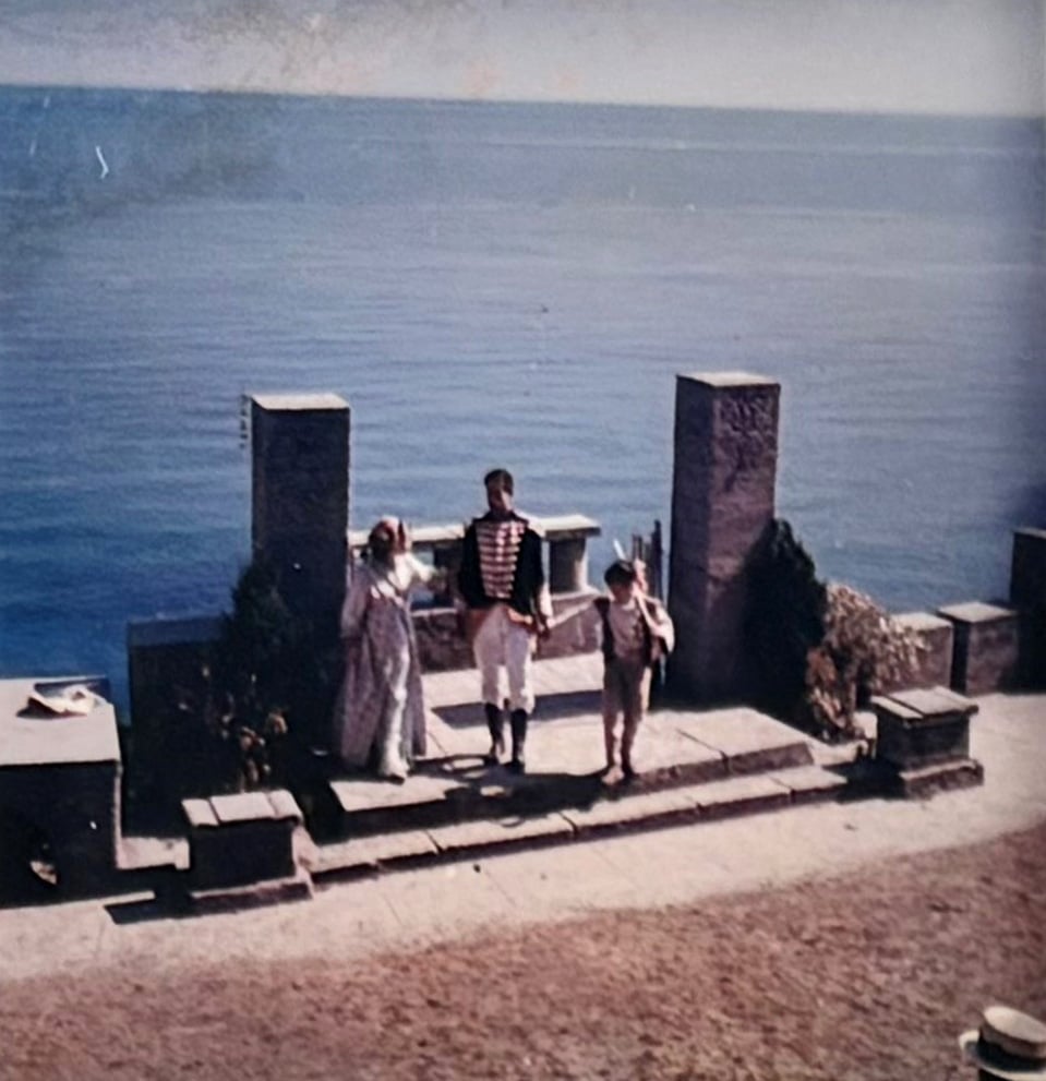 Actors on stage at The Minack Theatre with the sea behind
