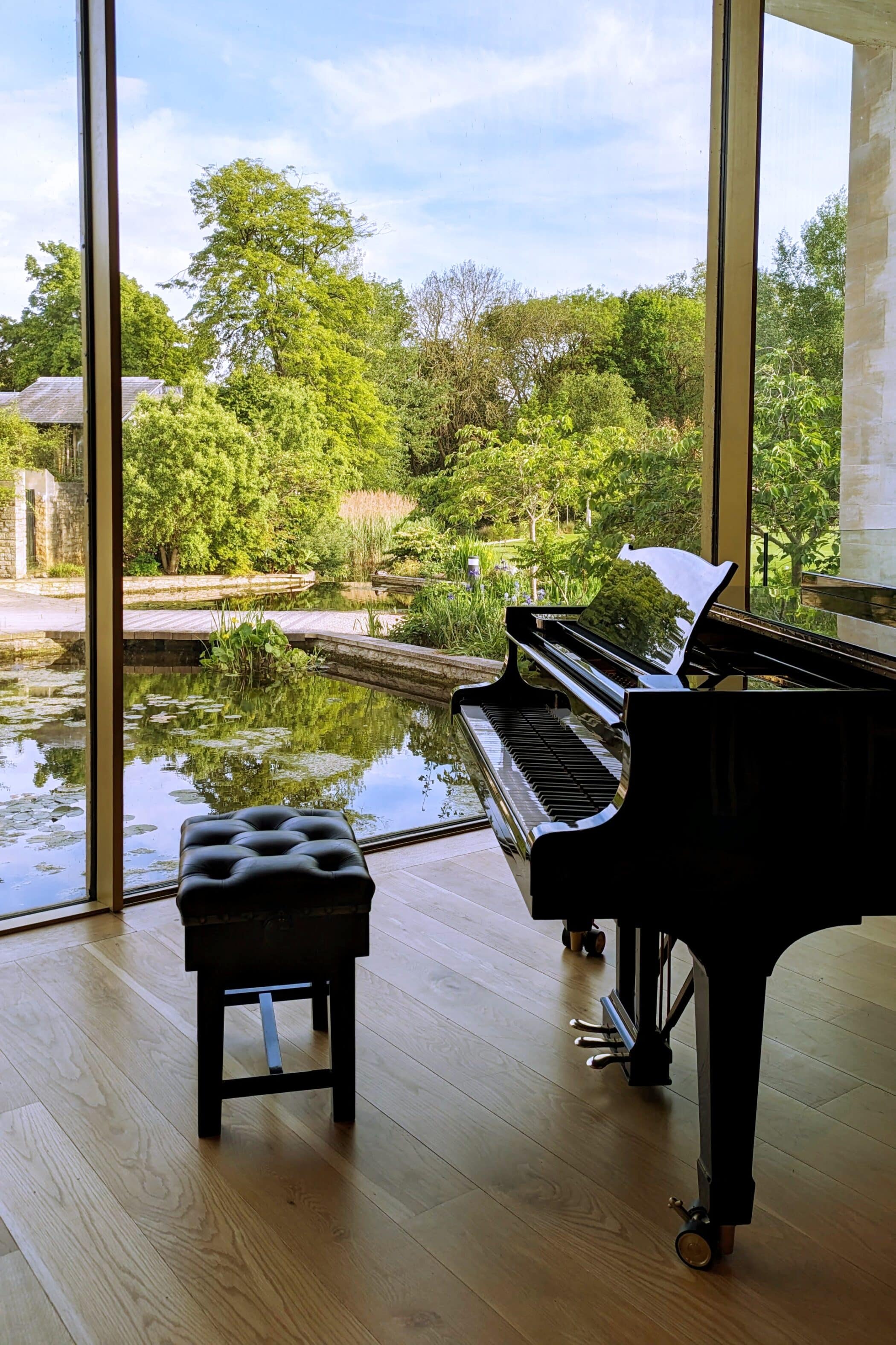 Grand piano in front of window showing lake and trees