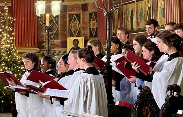 Choir singing in Chapel beside Christmas tree