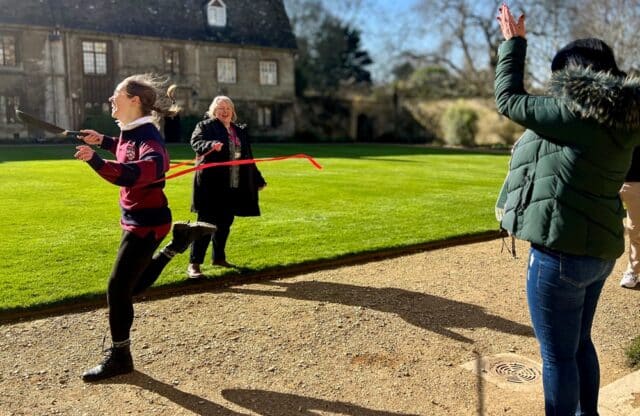 Student running with frying pan in pancake race